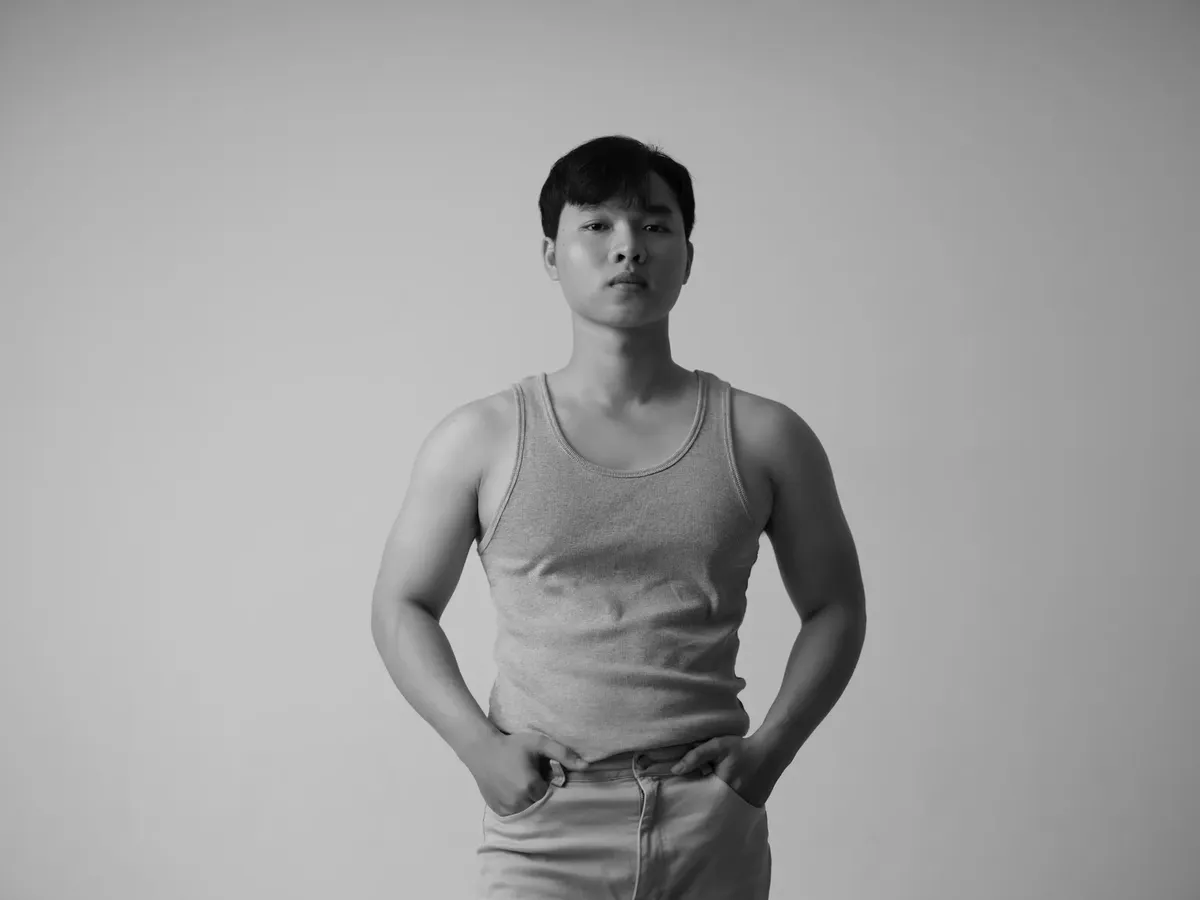 스스로 블랙 앤 블루 스타일의 아시아 남자 모델이 스튜디오에서 티셔츠를 입고 있는 사진.