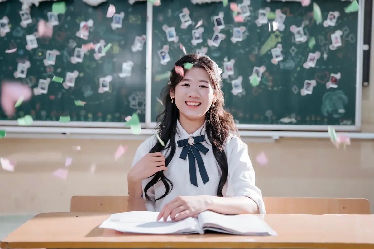 A cheerful student in uniform with confetti celebrating inside a classroom. Ideal for education and success themes.