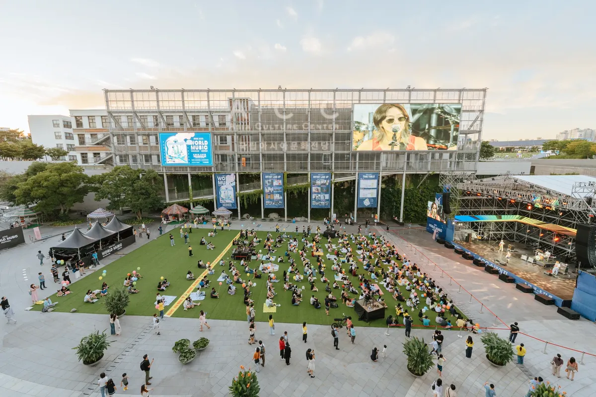 A lively outdoor music concert featuring an enthusiastic crowd at a cultural center.