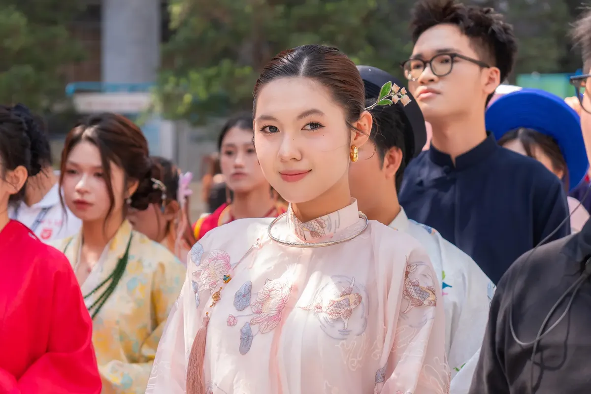 A diverse group dressed in vibrant traditional Asian clothing at an outdoor event.