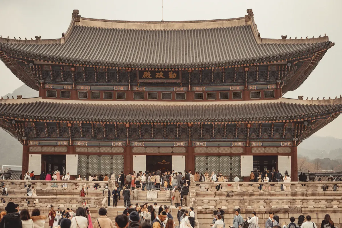 Discover the majestic Gyeongbokgung Palace, a top tourist attraction in Seoul, filled with visitors.