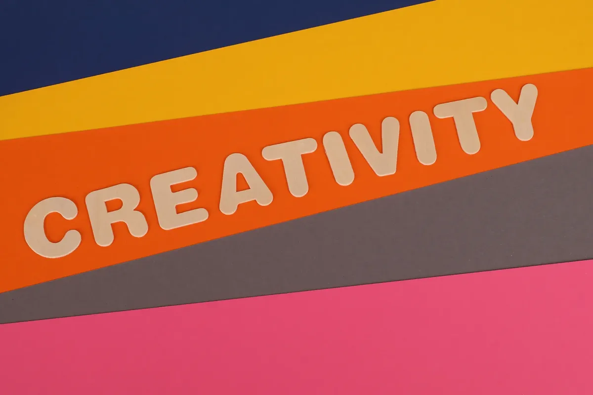 Vibrant layered paper design featuring the word 'Creativity' in bold letters.