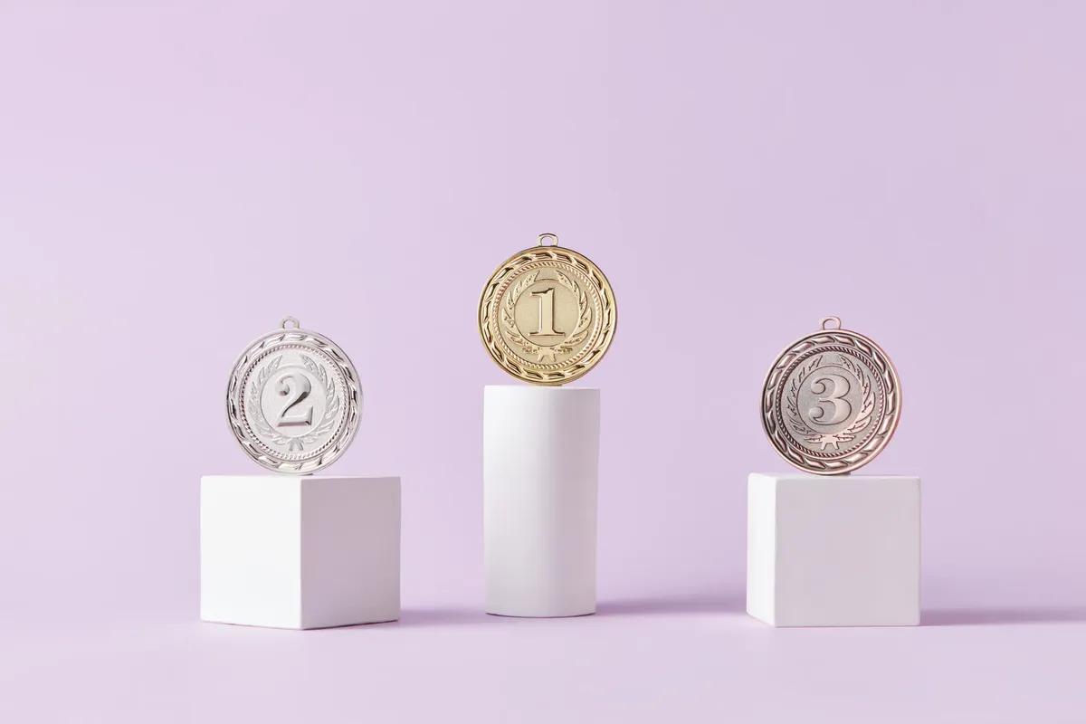 Medals on a podium against a soft pastel background, ideal for awards themes.
