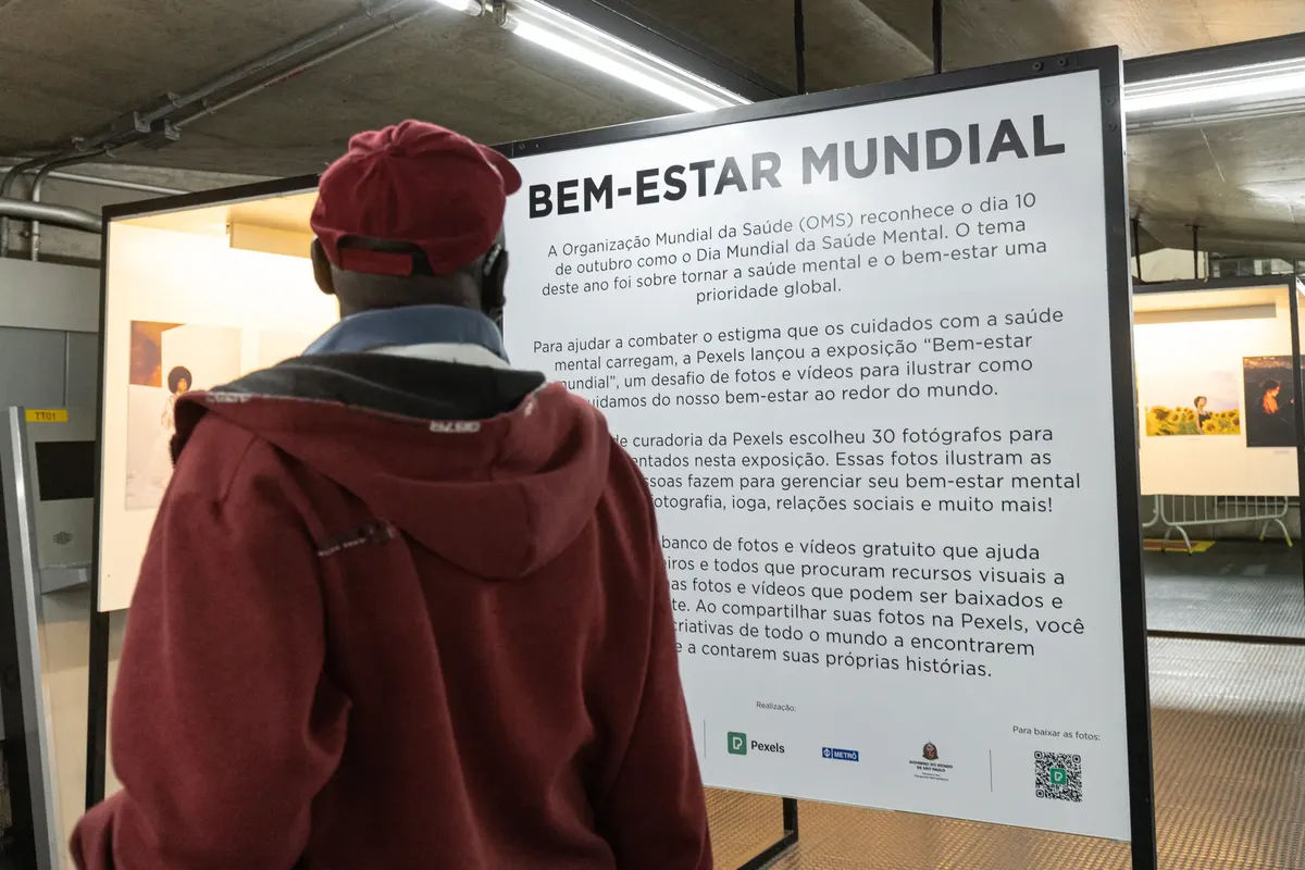 A person reads about global mental health awareness at a photo exhibition.