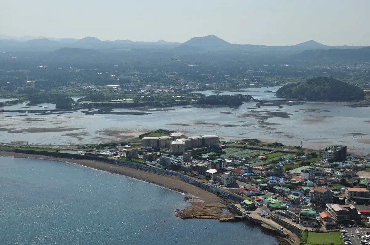 南韓の海岸沿いの町を捉る美しい航空写真で、自然と建築が融合した様子が見えます。