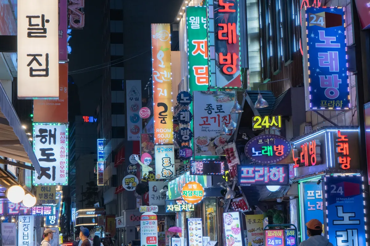 探索首爾南韓Myeongdong繁華夜景， showcasing 紅外線標誌與活潑的城市燈光。