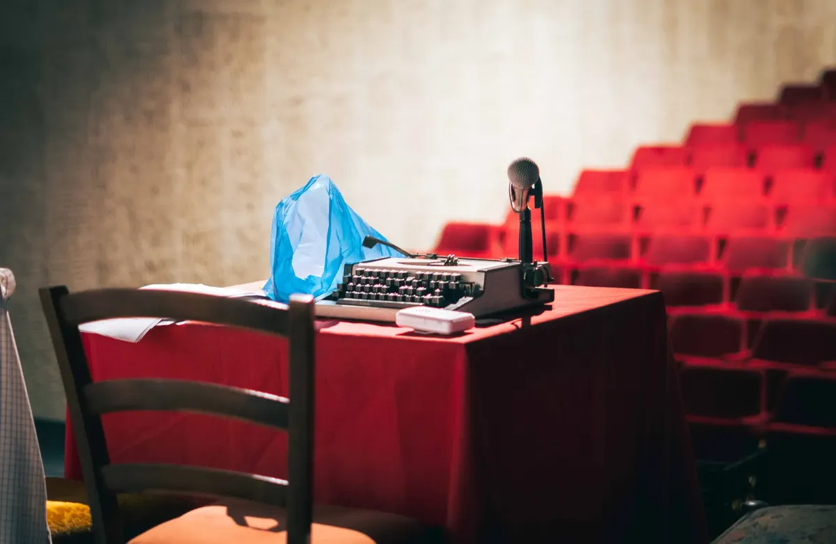 An old-fashioned typewriter with a microphone on a theatre stage sets a retro scene.