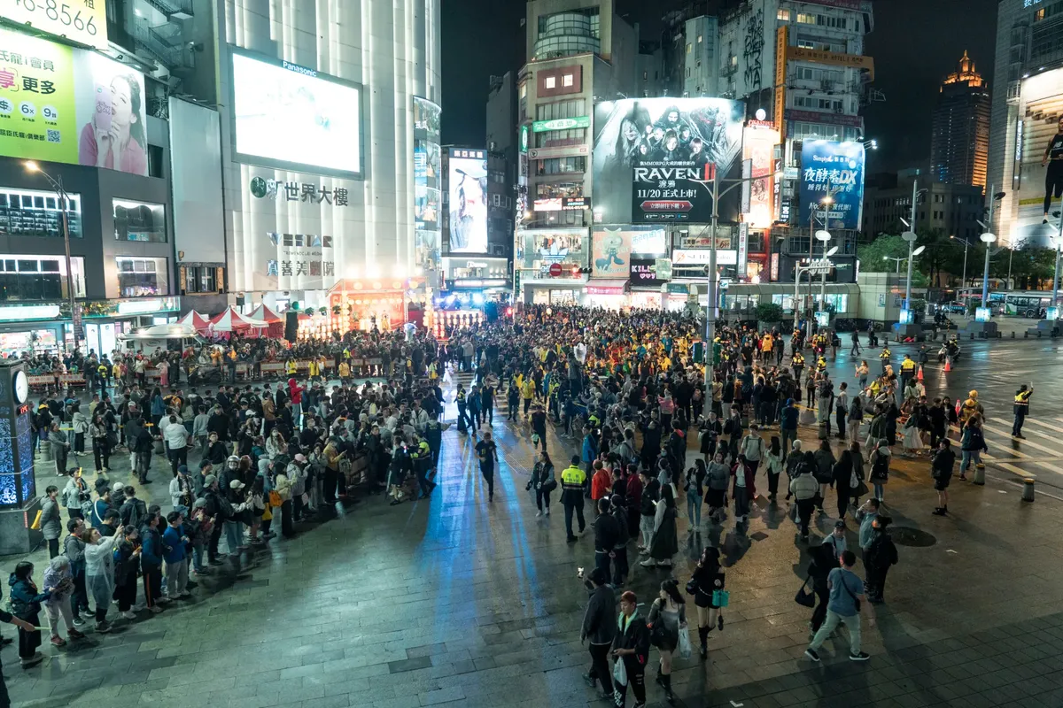 夜間在西門町聚集的熱鬧人群，展現台北活躍的都市生活。